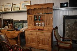 A stripped pine dresser raised on cupboard base, fitted two drawers