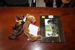 A mirrored picture frame with a photograph of King Charles and two commemorative teddies