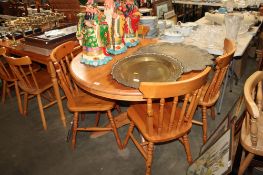 A pine circular extending dining table together with a set of four pine spindle back chairs