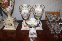 A pair of twin handled floral decorated ceramic vases having courting couple decoration and a