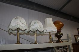 Three brass table lamps and a copper oil lamp converted to electricity