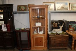 A stripped pine corner cabinet raised on cupboard base
