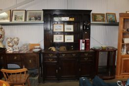 An oak dresser raised on cupboard base fitted five drawers with brass handles