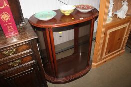 A bow front display cabinet with curved glass panels
