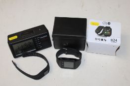 An Avon multi function watch, Fit Bit watch and a speaking clock