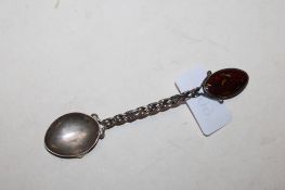 A white metal teaspoon set with amber coloured stone, approx. 13.5gms