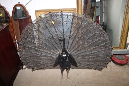 A cast iron fireguard in the form of a peacock approx. 110cm wide and 80cm high