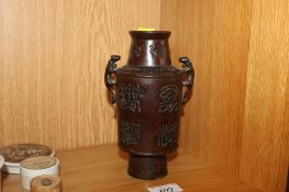 A Chinese bronze vase having twin beast head handles with character marks to base and various