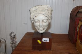 A replica of the head of a Kore, raised on wooden base