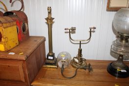 A brass Corinthian column table lamp; a brass desk lamp base and a wall light