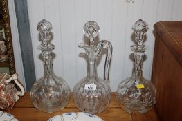 A pair of cut glass decanters and stoppers and a cut glass claret jug
