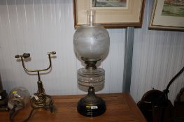 A brass oil lamp with clear glass reservoir