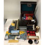 A small leather-effect storage box including guitar strings, ukulele strings, guitar picks,