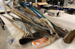 A collection of garden tools - spades, shovels, forks, edger, rake, brush, etc.
