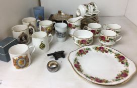 Twenty pieces of rose-decorated tea service, silver serviette ring, miniature metal canon,