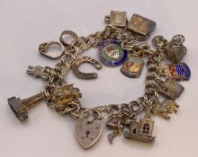 A silver hallmark charm bracelet 7" long with 15 assorted silver charms and a heart shaped padlock