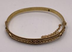 A 15ct gold vintage hinge bangle with detailed wire work, approximate weight 7.
