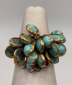 A gold Egyptian ring with turquoise cabochons, hallmark worn possibly 18ct, size L,