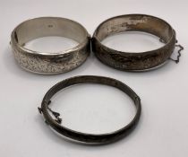 Three silver hallmark hinge bangles each with etched floral decoration, total approximate weight: 2.