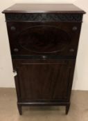 A 20th century Denby & Spinks mahogany single door cabinet with hand calved detail,