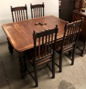 An early 20th century oak wind-out draw leaf dining table on barley twist legs and winder,