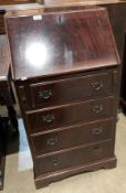 A dark mahogany finish reproduction bureau with fall-flap over four drawer base,