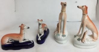 Two pairs of antique Staffordshire greyhounds - seated with rabbits 22cm high,