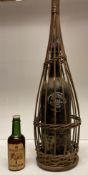 An old bottle of George V Jubilee 1935 Sandeman Vintage Port in wicker bottle basket and a small