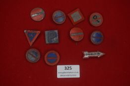 A group of German miniature road sign badges, including circular, triangular and directional forms