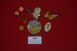 A mixed group of small German decorative pins and souvenirs, including carved and moulded examples