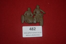 German Third Reich NSKK or SA-related tinnie or plaque, cast metal, depicting two uniformed
