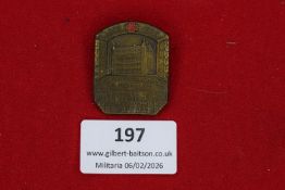 German Red Cross commemorative badge, bronze-toned shield form depicting building façade beneath Red