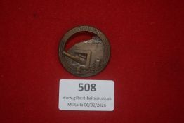 French Verdun commemorative badge, circular bronze example depicting a fortification and artillery