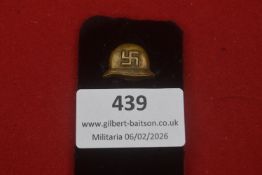 A Third Reich political lapel badge in the form of a gilt metal helmet bearing a swastika; good