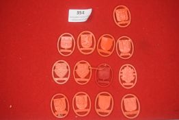 A group of German red and orange plastic WHW donation badges, oval form, depicting city arms