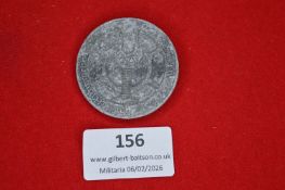 German Third Reich-era commemorative tinnie, circular form with central emblematic motif, grey metal