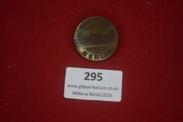 German patriotic round badge in brass, depicting a city building, inscribed “Reichstag – Besuch in