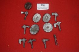 A larger mixed group of German WHW miniature weapon-themed badges, including axe-head and shield
