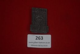 German Third Reich period tinnie, cast in darkened metal, featuring a soldier’s head within a