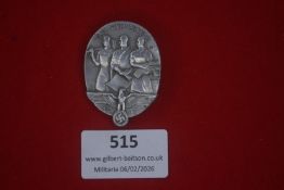 German Tag der Arbeit (May Day) 1935 badge, oval alloy example depicting three workers above a