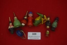 A group of German carved wooden spinning-top toys, comprising painted wooden figures and character