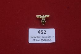 Third Reich eagle and swastika lapel badge, gilt-tone metal construction with applied black enamel