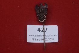 Third Reich stick pin featuring eagle clutching cogwheel with swastika, darkened metal finish,
