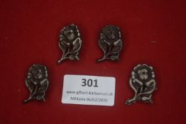 Four German rose-form lapel badges, silver-toned metal examples