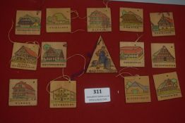 A large group of German WHW carved wooden regional plaques, each depicting traditional buildings and