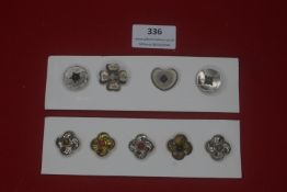 A group of German metal flower-form lapel badges, silvered and gilt examples with coloured central