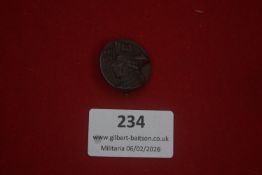 German tinnie badge featuring a helmeted profile head, darkened metal finish. Reverse with