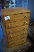 Small wooden collector’s chest of drawers, fitted six graduated drawers with brass knob handles,