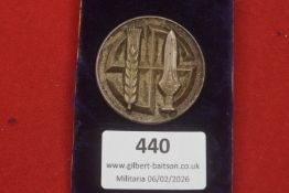 A Third Reich WHW (Winterhilfswerk) circular donation badge, cast in metal and depicting