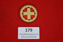 German Red Cross (DRK) cloth badge, circular, embroidered with a white cross over red floral
